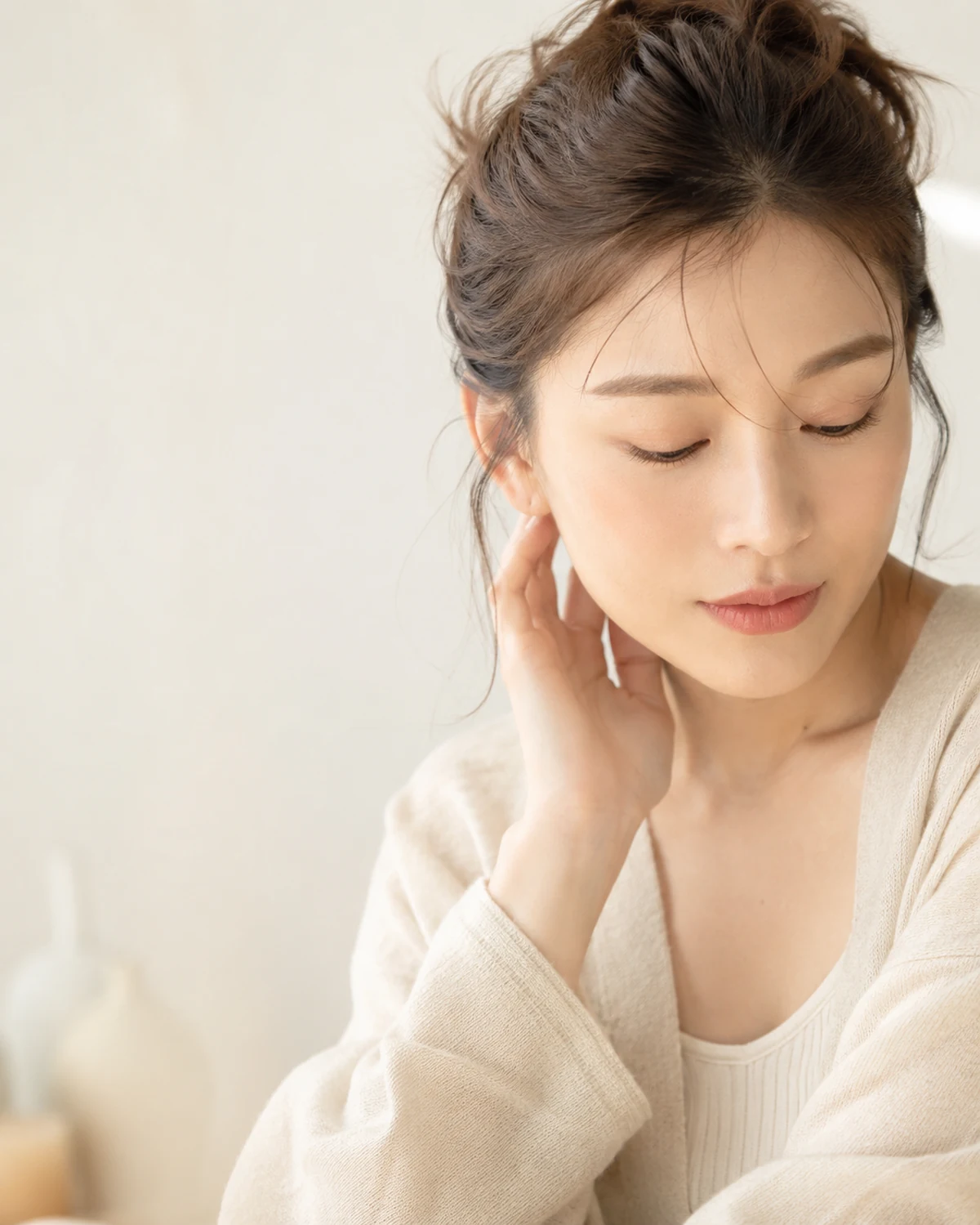 自然光のなかで、自分をいたわる静かなセルフケアの時間を過ごす女性